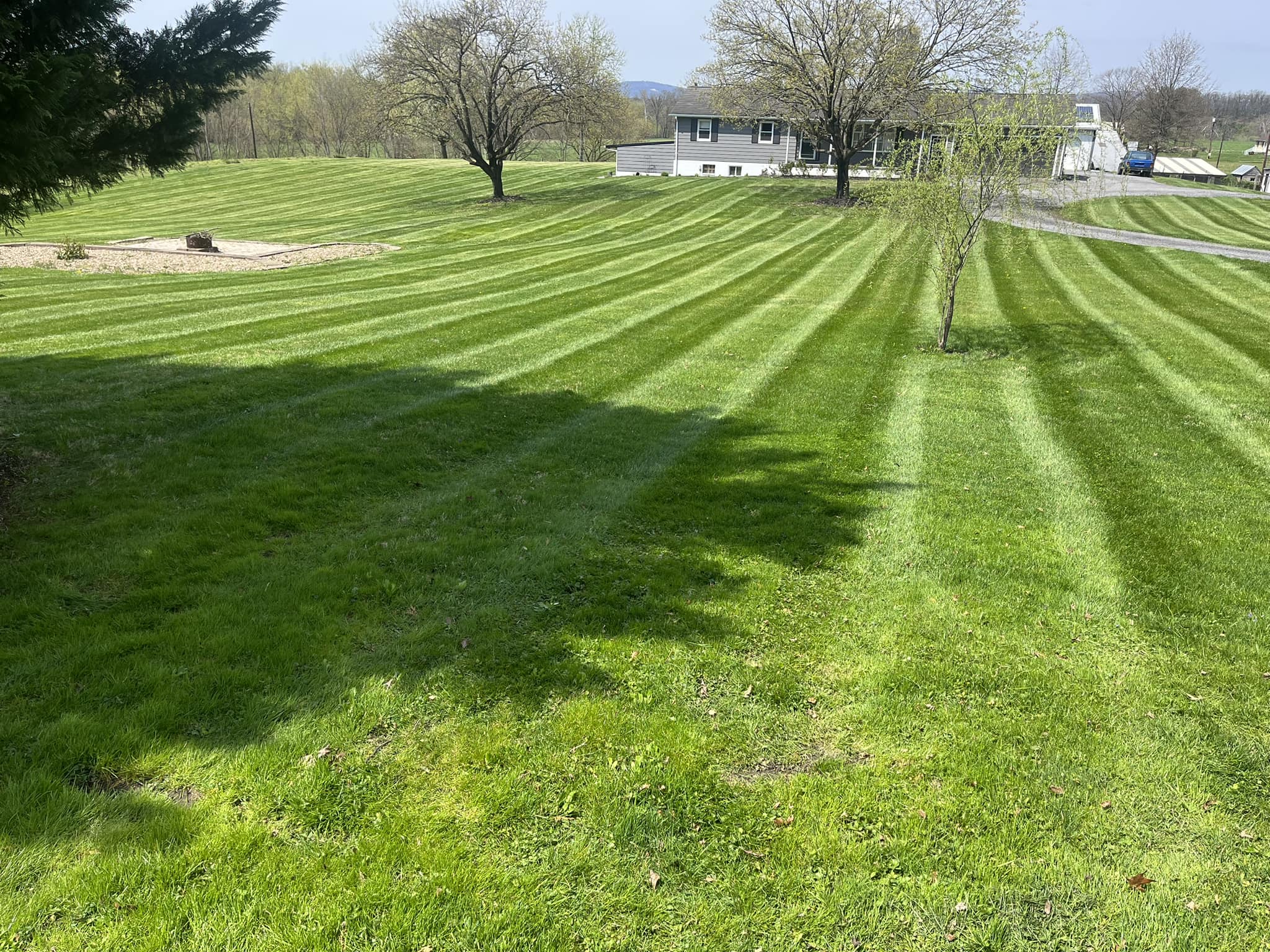 Precision striped mowing pattern across a large hillside lawn
